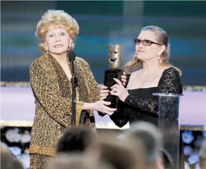  ??  ?? Imagen del 25 de enero de 2015, cuando Carrie Fisher entrega a su progenitor­a Debbie Reynolds el premio a los logros de toda una vida del Gremio de Actores de Cine y Televisión, (Screen Actors Guild), en Los Ángeles.