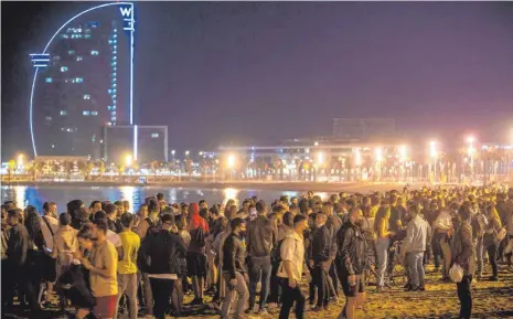 ?? FOTO: EMILIO MORENATTI/DPA ?? In Barcelona drängen sich Menschen am Strand. Wie in ganz Spanien feiern sie mit Hupkonzert­en, Böllern und Dosenbier nach mehr als sechs Monaten das Ende des Corona-Notstands.