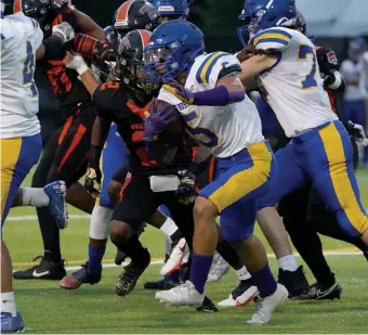  ?? MARy ScHwALm / bOStON HeRALd ?? TAKING OFF: East Boston running back Randy Bermudez (5) rushes past Brighton defender Jathan Greene (2) during the first half Friday night in Brighton.