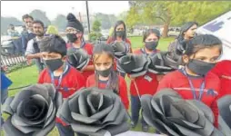  ?? PTI ?? Children wearing masks hold replicas of black roses as they attend a demonstrat­ion to spread awareness about air pollution on Children's Day in New Delhi on Tuesday.