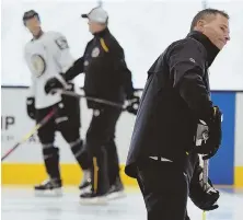  ?? STAFF PHOTOS BY FAITH NINIVAGGI ?? TOGETHER AGAIN: Above, coach Bruce Cassidy skates during training camp at Warrior Ice Arena Friday, when the Bruins worked out as a split squad for a final time before teammates returned from China. At right, Anders Bjork is watched by goalie coach Bob Essena.