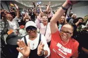  ?? HENRIETTA WILDSMITH/THE TIMES ?? Mary Pickens (center) is surrounded by others as they celebrate at the Henry Whitehorn watch party for Caddo Sheriff election results, Saturday at Hilton Shreveport.