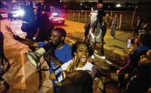  ?? SHABAN ATHUMAN / DALLAS MORNING NEWS ?? Dominique Alexander attempts to control protesters as they march in the streets on Monday at the Jack Evans Police Headquarte­rs in Dallas.