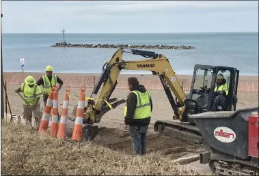  ?? KEVIN MARTIN — THE MORNING JOURNAL ?? A crew at Lakeview Park in Lorain repairs the sidewalk near the boardwalk March 22.