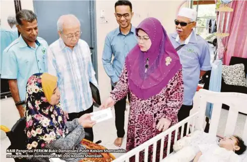 ??  ?? NAIB Pengerusi PERKIM Bukit Damansara Puteh Kalsom Shamsuddin menyampaik­an sumbangan RM1,000 kepada Shamsiah .