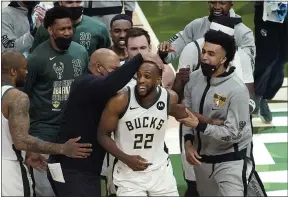  ?? PAUL SANCYA — THE ASSOCIATED PRESS ?? Bucks forward Khris Middleton (22) celebrates with teammates during the second half against the Suns in Game 4of the NBA Finals on July 14in Milwaukee.