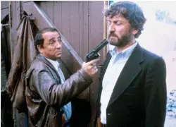  ??  ?? Récompense. Dans « La Guerre des polices », de Robin Davis, en 1979, tenant Claude Rich en joue. Ce rôle de flic lui vaudra son seul césar de meilleur acteur.