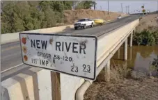  ??  ?? A northbound motorist pulls a boat across the New River Bridge 58-120 on Highway 111 north of Brawley on May 3, 2013. The water flowing north to the Salton Sea on the New River (right) has a brown color. IV PRESS FILE PHOTO