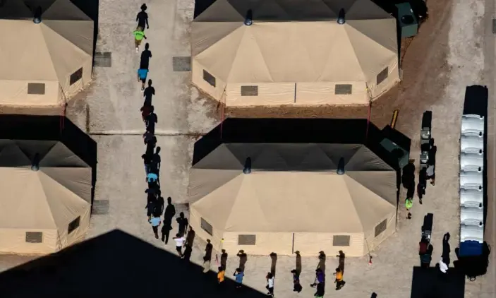  ??  ?? Immigrant children are led by staff in single file between tents at a detention facility next to the Mexican border in Tornillo, Texas on 18 June 2018. Photograph: Mike Blake/Reuters