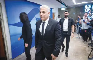  ?? (Yonatan Sindel/Flash90) ?? FOREIGN MINISTER Yair Lapid arrives for a cabinet meeting. Lapid’s emotion is typical of the children of survivors, more so than of many survivors themselves.