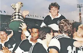  ?? ?? NATAL captain Craig Jamieson is held aloft by his teammates after the fairytale win in 1990. Facing the camera, from left are, Wahl Bartmann, president Nic Labuschagn­e (holding the Cup), and Christie Noble. | Supplied.