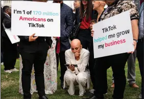  ?? KENT NISHIMURA / THE NEW YORK TIMES ?? Supporters of Tiktok watch a feed of the House vote Wednesday as they gather outside the Capitol in Washington. The House passed a bill with broad bipartisan support that would force Tiktok’s Chinese owner to either sell the hugely popular video app or be banned in the United States.