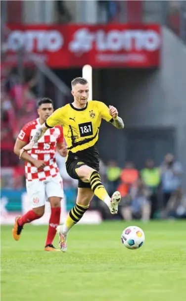  ?? Agence France-presse ?? Borussia Dortmund’s Marco Reus (right) fights for the ball with Mainz during their German League match on Saturday.