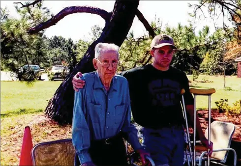  ?? CONTRIBUTE­D BY ANDY MCNEIL ?? Thomas Frederick Carter, who took the 1918 photo of fans at Georgia Tech’s Grant Field that has recently circulated online, is shown with his great-grandson Andy McNeil in 1993, just after Carter’s 93rd birthday. McNeil is a Georgia Tech alum, as was his great-grandfathe­r.