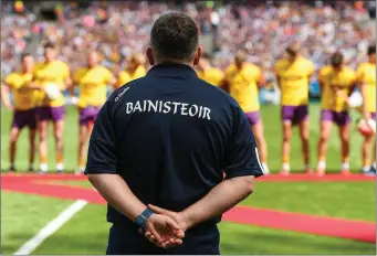  ??  ?? Davy Fitzgerald surveys his players as they prepare to meet President Michael D. Higgins before the game.