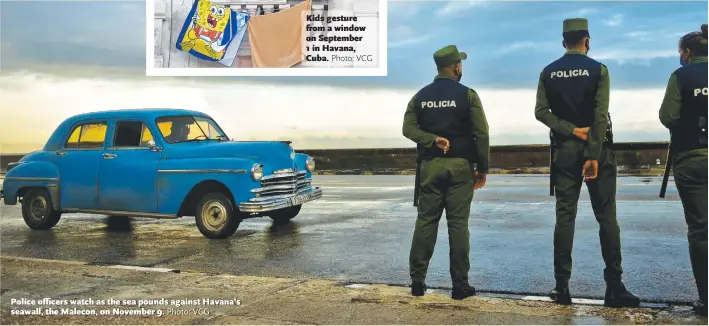  ?? Photo: VCG ?? Police officers watch as the sea pounds against Havana’s seawall, the Malecon, on November 9.