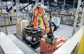  ?? CP PHOTO JEFF MCINTOSH ?? A robot unloads a pallet of cat food at a Walmart distributi­on centre in Calgary on March 28. Walmart Canada is planning to bring robots to two Ontario distributi­on centres.