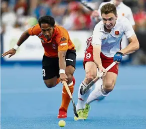  ??  ?? The ball is mine: Malaysia’s Tengku Ahmad Tajuddin (left) beating England’s Harry Martin to the ball in the World Hockey League Semi-Final third-place playoff in London on June 25. — AP