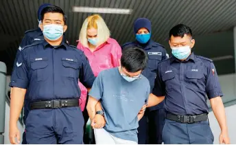  ?? — Bernama photo ?? Police personnel escort the couple from the court.