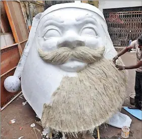  ?? REUTERS ?? An artisan prepares a giant face of Santa Claus made of polystyren­e, at a roadside workshop ahead of Christmas celebratio­ns, in Kolkata, on Thursday.