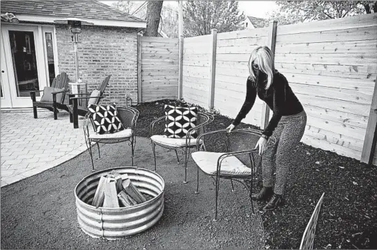  ?? ERIN HOOLEY/CHICAGO TRIBUNE PHOTOS ?? KatieWrobe­l arranges chairs in her newly remodeled backyard space Nov. 5 in Evanston.