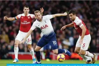  ??  ?? LONDON: Tottenham Hotspur’s English striker Harry Kane (C) vies with Arsenal’s Greek defender Sokratis Papastatho­poulos (R) during the English Premier League football match between Arsenal and Tottenham Hotspur at the Emirates Stadium in London yesterday. — AFP