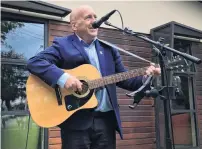  ??  ?? Special guest . . . Central Otago Mayor Tim Cadogan sings the opening number at the inaugural Alexandra Buskers Festival yesterday, watched by an appreciati­ve crowd.