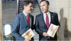  ?? JUSTIN TANG/THE CANADIAN PRESS ?? Prime Minister Justin Trudeau speaks with Finance Minister Bill Morneau on Tuesday before Morneau delivered the Liberals’ first budget, which contained a $40-billion growth adjustment.