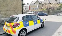  ??  ?? The boarded-up house and police at the scene of the incident on Beaconsfie­ld Street in Haslingden