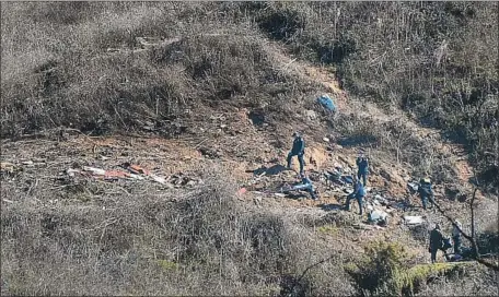  ?? Christina House Los Angeles Times ?? OFFICIALS continue their investigat­ion Monday at the site of the helicopter crash that killed Kobe Bryant and eight others in Calabasas.