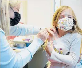  ?? TED S. WARREN/AP ?? Shauna Andrus, a volunteer nurse, gives the first dose of the Pfizer COVID-19 vaccine to Emmy Slonecker, 7, on Tuesday at the UW Medical Center in Seattle.