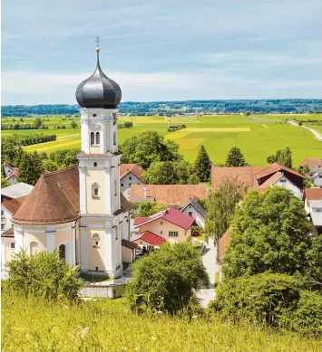  ??  ?? Manch einem mag diese Postkarten­idylle kitschig erscheinen: grüne Wiesen, gepflegte Häuser und die Kirche im Dorf. Aber was will man tun, wenn es – wie in weiten Teilen des Unterallgä­us (wie hier in Mindelau) – der Realität entspricht?