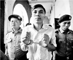  ??  ?? Kyaw Soe Oo arrives escorted by police before a court hearing in Yangon, Myanmar.