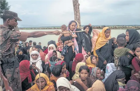  ??  ?? SOVEREIGNT­Y PREVAILS: Rohingya refugees fleeing what some call ethnic cleansing await aid after crossing the Naf River from Myanmar, near Palong Khali in Bangladesh.