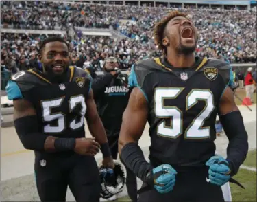  ?? STEPHEN B. MORTON — THE ASSOCIATED PRESS ?? Jaguars linebacker­s Donald Payne (52) and Blair Brown (53) celebrate after defeating the Bills in a wild-card game on Jan. 7 in Jacksonvil­le, Fla.