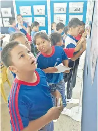  ??  ?? SEBAHAGIAN murid SK Taginambur mencatat nota selepas melihat pameran sempena Hari Malaysia.