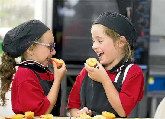  ?? CHRISTEL YARDLEY/STUFF ?? Hamilton’s Rhode Street School has a healthy eating programme in place instead of a tuck shop to provide wholesome cooked lunches. Reivon Love, 6, left, and Charlotte Commins, 5, help prepare some healthy snacks.
