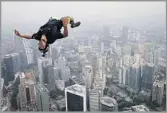  ?? Vincent Thian Associated Press ?? HIGH OCTANE
Vincent Reffet leaps from Malaysia’s Kuala Lumpur Tower during a 2013 BASE jumping event.