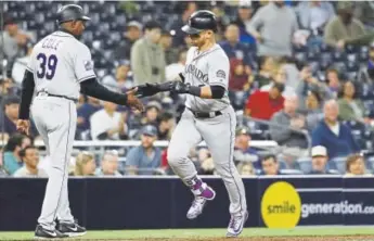  ?? Gregory Bull, The Associated Press ?? The Rockies’ Gerardo Parra is greeted by third-base coach Stu Cole after hitting a three-run homer during the sixth inning Monday night in San Diego.