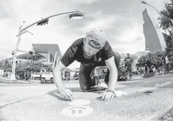  ?? Photos by Steve Gonzales / Staff photograph­er ?? Astros pitcher Chris Devenski puts smiley faces on his mural during the Via Colori street painting festival downtown on Saturday. The two-day event raises money for The Center for Hearing and Speech.