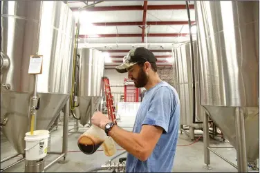  ?? NWA Democrat-Gazette/BEN GOFF • @NWABENGOFF ?? Brant Bishop, director of quality at Ozark Beer Co., inspects a sample of the brewery’s BDCS 2018 bourbon barrel-aged double cream stout Friday at Ozark Beer Co. in Rogers. The brewery has partnered with Crystal Bridges Museum of American Art in...