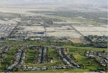  ?? CHRIS CARLSON/THE ASSOCIATED PRESS ?? Lush green golf courses border the edge of the desert in Palm Springs, Calif. Cities expected to slash water use in the drought are revolting against Gov. Jerry Brown’s mandatory water restrictio­ns.