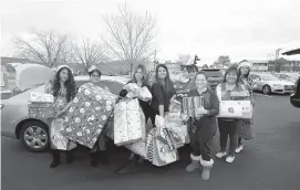  ??  ?? Blue Cross Blue Shield of New Mexico brought presents to put a smile on the faces of children in the Grandparen­ts Raising Grandchild­ren program on Dec. 11.