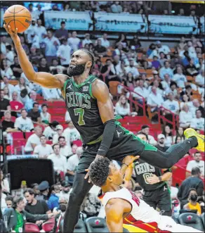  ?? Lynne Sladky The Associated Press ?? Celtics guard Jaylen Brown soars to the basket while being fouled by Heat guard Kyle Lowry in Boston’s win Wednesday at FTX Arena.