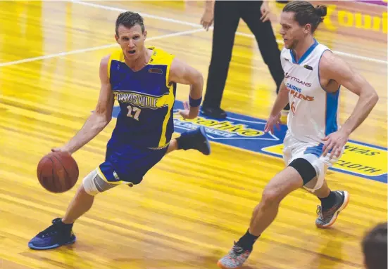  ?? FIGHTING BACK: Townsville Heat swingman Peter Crawford is marked by Cairns Marlins guard Damon Heuir at Murray Stadium. Picture: SCOTT RADFORD- CHISHOLM ??