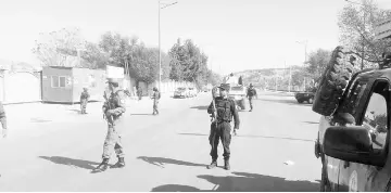  ??  ?? Afghan policemen keep watch at the site of an attack at a private television station in Kabul, Afghanista­n. — Reuters photo