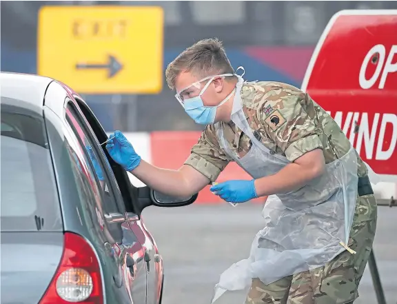  ?? Picture: PA. ?? A soldier from 2 Scots Royal Regiment of Scotland takes a test sample at a Covid-19 testing centre at Glasgow Airport.