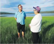  ??  ?? Tlingit band councillor Duane Aucoin and elder Madeleine Jackson on the banks of Teslin Lake, near where her family used to hold its traditiona­l fish camp.