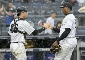  ?? BILL KOSTROUN — THE ASSOCIATED PRESS ?? Yankees pitcher Aroldis Chapman, right, and catcher Kyle Higashioka celebrate after the Yankees defeated the Texas Rangers 5-3 on Saturday.
