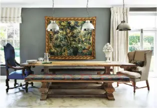  ??  ?? Right At one end of the capacious kitchen, an antique table and benches sit between windows overlookin­g the garden. An antique tapestry decorates the wall